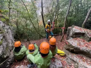 4 personnes equipes en tenue de speleologie regardent le briefing du guide de speleologie dans les gorges dAgnielles 300x225