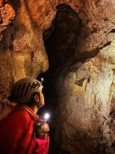 Deux enfants eclairent le plafond dune grotte a Sisteron 225x300