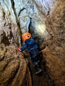 Un enfant eclaire devant lui la galerie dune grotte naturelle a Sisteron 1 225x300