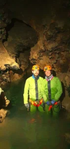 deux personnes equipes dune tenue de speleologie se tiennent debout dans un lac souterrain du Puits des Bans 727x1536 1 142x300