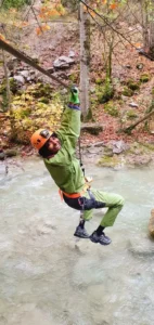 une personne en tenue de speleologie traverse la riviere des gorges dAgnielles en tyrolienne 727x1536 1 142x300