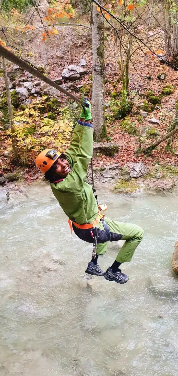 une personne en tenue de speleologie traverse la riviere des gorges dAgnielles en tyrolienne 727x1536 1