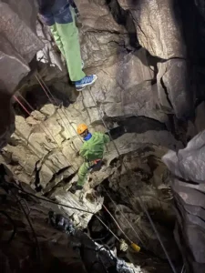 vue sur un speleologue qui descend en rappel depuis le pont de singe de la via souterrata de la Tune 225x300